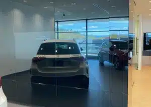 White Mercedes SUV in showroom reflecting in black glass wall