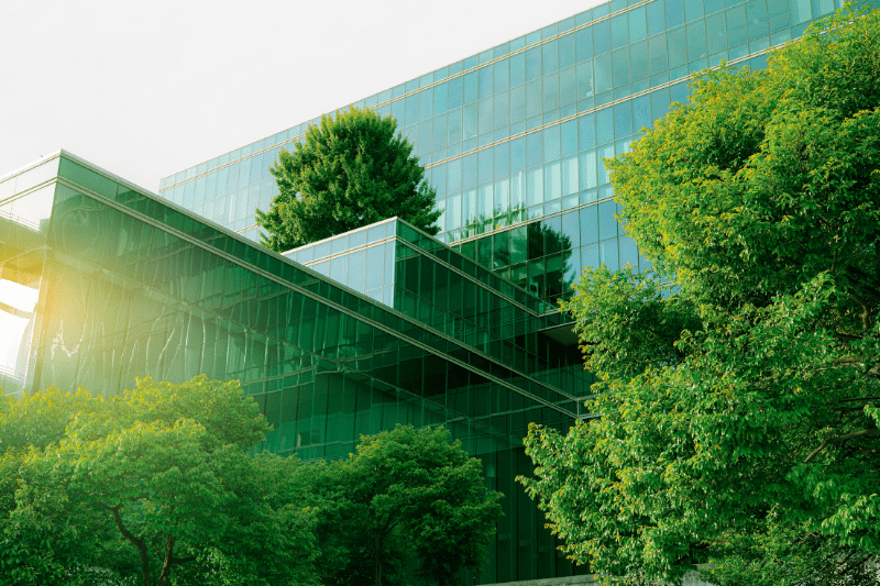 Glass building surrounded by green trees for sustainability