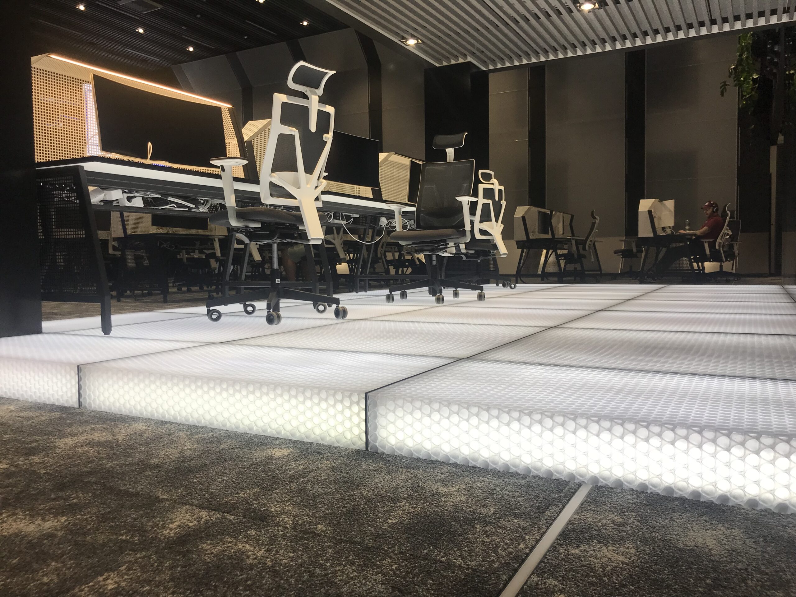 Backlit clear-PEP ECO PC stage honeycomb flooring in a modern workplace