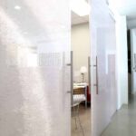 Translucent honeycomb panel doors along a bright office corridor
